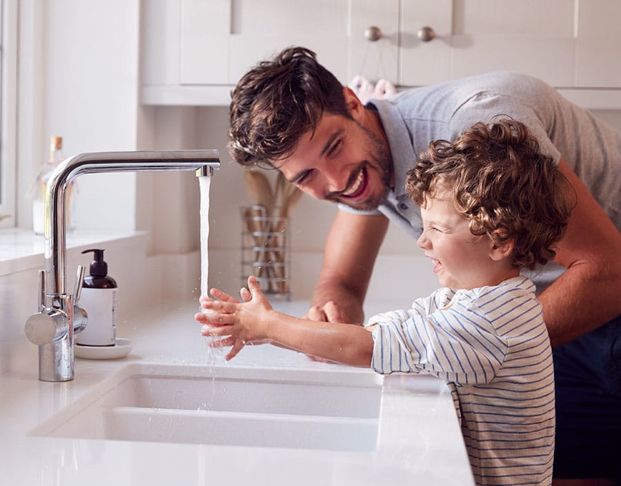 Hard water flowing from kitchen faucet during hand washing