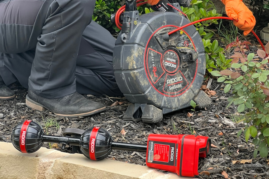 Plumber using a sewer camera and locater to pinpoint a break in an underground sewer line in Southlake.