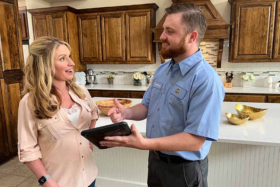 CW Service Pros technician explaining thermostat options