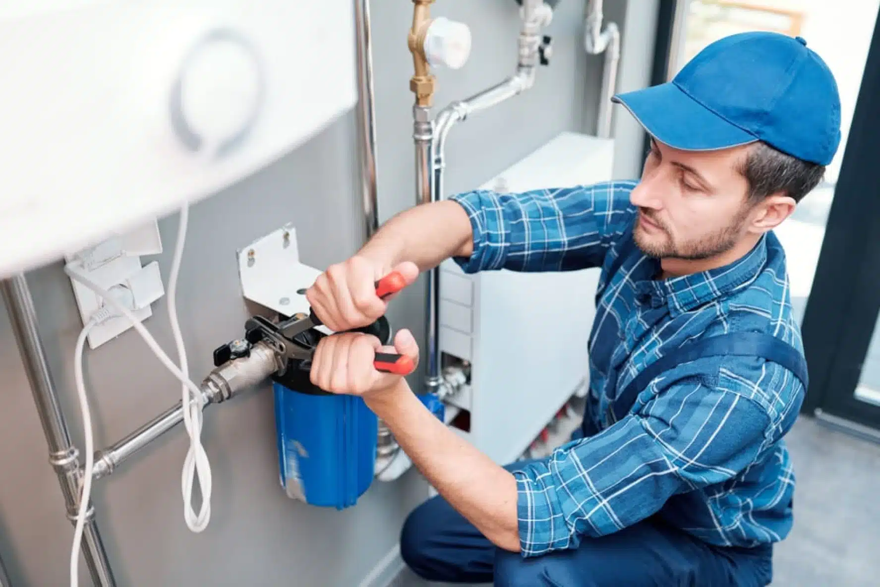 An experienced plumber installs a water filtration system, focusing intently on connecting pipes and fixtures to ensure clean and safe drinking water for the household.
