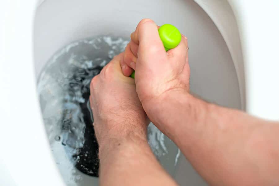 hands plunging toilet