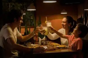 mom, dad, and child cheers at restaurant